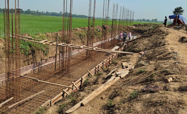 Construction of a foundation with steel rebar beside green rice fields at the Gurap campus